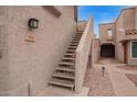 Exterior staircase leading to a desert-toned condo, with textured walls and decorative gravel landscaping at 2834 S Extension Rd # 2005, Mesa, AZ 85210
