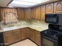 Functional kitchen featuring wood cabinets, granite countertops, a double sink, and modern black appliances at 3115 N 26Th St, Phoenix, AZ 85016