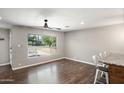 A bright living room features wood floors, neutral walls, and a large picture window showcasing the outdoor scenery at 3837 E Yale St, Phoenix, AZ 85008