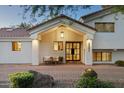 Inviting entryway with a covered porch, stylish lighting, and a modern steel front door at 5202 E Larkspur Dr, Scottsdale, AZ 85254