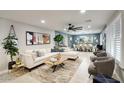 Spacious living room featuring a plush sectional, stylish decor, and an open concept layout with the dining area at 5441 E Wethersfield Rd, Scottsdale, AZ 85254