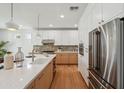 Modern kitchen with white cabinets, stainless steel appliances, and an island with quartz countertop at 5537 E Earll Dr, Phoenix, AZ 85018