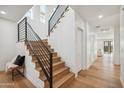 Modern staircase with light wood steps, black railing and accent bench by the stairs at 5537 E Earll Dr, Phoenix, AZ 85018