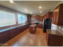 This kitchen features a center island, wood cabinets, granite counters, and stainless steel appliances at 5635 W Huntington Dr, Laveen, AZ 85339