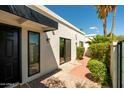 Modern home exterior features sleek black window trim, and a walkway lined with green bushes at 6102 E Friess Dr, Scottsdale, AZ 85254
