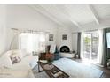 Bright living room with white vaulted ceilings, fireplace, and sliding door to patio at 6349 N 78Th St # 105, Scottsdale, AZ 85250