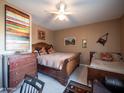 Comfortable bedroom with ceiling fan, dark wood furniture, and decorative wall art at 6535 E Superstition Springs Blvd # 217, Mesa, AZ 85206