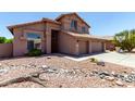 Two-story home with a red tile roof, three-car garage, and desert landscaping at 7179 W Surrey Ave, Peoria, AZ 85381