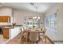 Bright dining room with a rustic table, modern chandelier, and sliding glass doors to the backyard at 8178 W Tonopah Dr, Peoria, AZ 85382