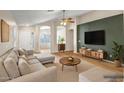 Comfortable living room featuring hardwood floors, a ceiling fan, and neutral-colored sectional sofa at 8178 W Tonopah Dr, Peoria, AZ 85382