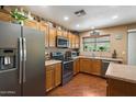 Well-equipped kitchen with stainless steel appliances, wood cabinets, and a view of the backyard at 8259 W Carol Ave, Peoria, AZ 85345