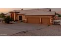 Charming home features a 2-car garage and stone landscaping with an expansive driveway at 8351 S Summit Dr, Casa Grande, AZ 85193
