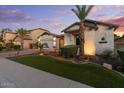A beautiful single-Gathering home featuring lush landscaping, mature palm trees, and an extended driveway at 883 E Hampton Ln, Gilbert, AZ 85295