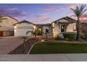 Charming single-story home featuring a three-car garage, lush landscaping, and inviting curb appeal at 883 E Hampton Ln, Gilbert, AZ 85295