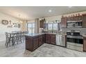 Modern kitchen featuring granite countertops, stainless steel appliances, and dark wood cabinetry at 8912 N Johnson Ct, Maricopa, AZ 85139