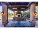 Beautiful outdoor patio featuring a fireplace, comfortable seating, and desert landscaping at 10010 E Blue Sky Dr, Scottsdale, AZ 85262