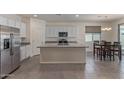 Spacious kitchen features stainless steel appliances, granite island, and dining area at 18388 W Ida Ln, Surprise, AZ 85387