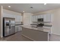Bright kitchen boasts stainless steel appliances and large island with granite countertops at 18388 W Ida Ln, Surprise, AZ 85387