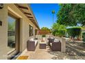 Relaxing patio area with wicker furniture, a stone pathway, and lush greenery creates an inviting outdoor space at 1850 E Maryland Ave # 18, Phoenix, AZ 85016