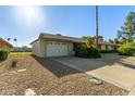 Single-story home boasts a two-car garage, desert landscaping and a well-kept front yard at 18842 N Lakeforest Dr, Sun City, AZ 85373