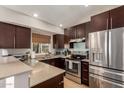 Modern kitchen features stainless steel appliances, granite countertops, and dark wood cabinets at 19414 N 3Rd Ave, Phoenix, AZ 85027