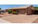 Exterior home view showing brick driveway, desert landscaping and attached garage at 2302 E Monte Cristo Ave, Phoenix, AZ 85022