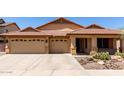 Charming single-story home with a three-car garage, desert landscaping, and a tile roof at 3028 W Parkside Ln, Phoenix, AZ 85027