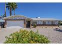 Charming single-story home with desert landscaping, two-car garage and brick accents at 3362 E Carol Ave, Mesa, AZ 85204