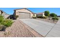 Low angle of concrete driveway leading to a two-car garage, framed by desert landscaping and a blue sky backdrop at 36515 N Takota Trl, San Tan Valley, AZ 85140