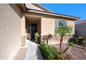 Welcoming front porch features a dark wood door, desert landscaping, and stone accents, enhanced by a clear, sunny day at 36515 N Takota Trl, San Tan Valley, AZ 85140