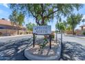 Pecos North community sign featuring lush green trees and flowering plants, welcoming residents and visitors alike at 4519 E Amberwood Dr, Phoenix, AZ 85048