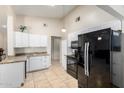 Bright eat-in kitchen features tile floors, white cabinets, modern black appliances and granite counters at 511 E Purdue Ave, Phoenix, AZ 85020