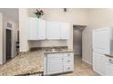 Bright kitchen featuring white cabinets, granite countertops, a stainless steel sink, and tile flooring at 511 E Purdue Ave, Phoenix, AZ 85020