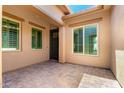 Charming courtyard featuring tan stucco walls, neutral trim, and beautiful tiled flooring at 5446 S Sandstone Ct, Gilbert, AZ 85298