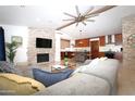 Open-concept living room features a stone fireplace, vaulted ceilings, and seamless flow into the kitchen at 6920 E Beverly Ln, Scottsdale, AZ 85254
