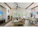 Bright living room featuring a fireplace, beamed ceilings, and seamless flow to the dining area at 7221 E Eclipse Dr, Scottsdale, AZ 85266