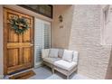 Charming entrance featuring a cozy sitting area and a beautifully decorated wooden door with a wreath at 7800 E Lincoln Dr # 2029, Scottsdale, AZ 85250