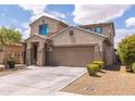Charming two-story home featuring a well-manicured lawn, tree, and an attached two-car garage at 8924 N 102Nd Ln, Peoria, AZ 85345