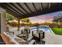 Relaxing covered patio with comfortable seating, outdoor dining, fire pit, and pool view to entertain Gathering and friends at 9669 E Chino Dr, Scottsdale, AZ 85255