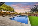 Beautiful swimming pool with stone surround, waterfall feature, and ample seating to enjoy amazing Arizona sunsets at 9669 E Chino Dr, Scottsdale, AZ 85255