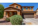 Attractive two-story home with a well-manicured front yard and a convenient two-car garage at 12128 W Range Mule Dr, Peoria, AZ 85383