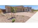 Well-manicured front yard with a three-car garage and a charming single-story facade at 12389 W Marguerite Ave, Avondale, AZ 85323