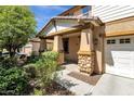 Inviting front porch with stone accents on the columns and well-maintained landscaping around the entrance at 13722 N 150Th Ln, Surprise, AZ 85379