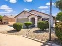 Inviting single-story home with a well-kept lawn, desert landscaping, and a welcoming entrance at 14211 N 149Th Dr, Surprise, AZ 85379