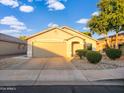 Charming single-story home featuring a well-manicured front yard with lush landscaping and a two-car garage at 14211 N 149Th Dr, Surprise, AZ 85379