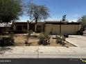 Single-story home with stucco siding, flat roof, attached garage, and xeriscaped front yard at 1541 E Las Palmaritas Dr, Phoenix, AZ 85020