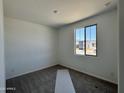 Bright bedroom features a window with a view and neutral carpeting, ready for personalization at 15785 W Beryl Ave, Waddell, AZ 85355
