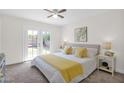 Bright bedroom with neutral carpet, ceiling fan, and patio doors leading to the backyard at 16421 N 65Th Pl, Scottsdale, AZ 85254