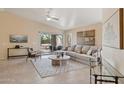 Bright living room with a large sectional couch, decorative rug, and sliding glass doors to an outdoor space at 17141 E Rockwood Dr, Fountain Hills, AZ 85268