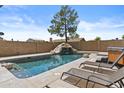 Relaxing backyard pool area with a rock waterfall feature, lounge chairs, and mature landscaping at 17244 N 29Th Ave, Phoenix, AZ 85053
